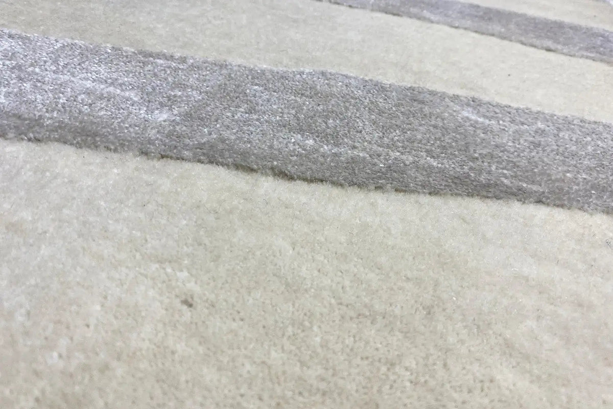 Rug with horizontal stripes in beige and gray, close-up of the pattern
