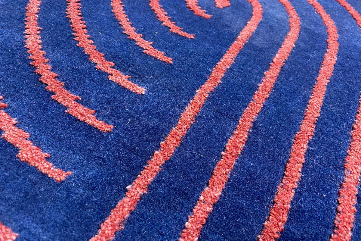 Carpet with blue pile and orange spiral lines, close-up