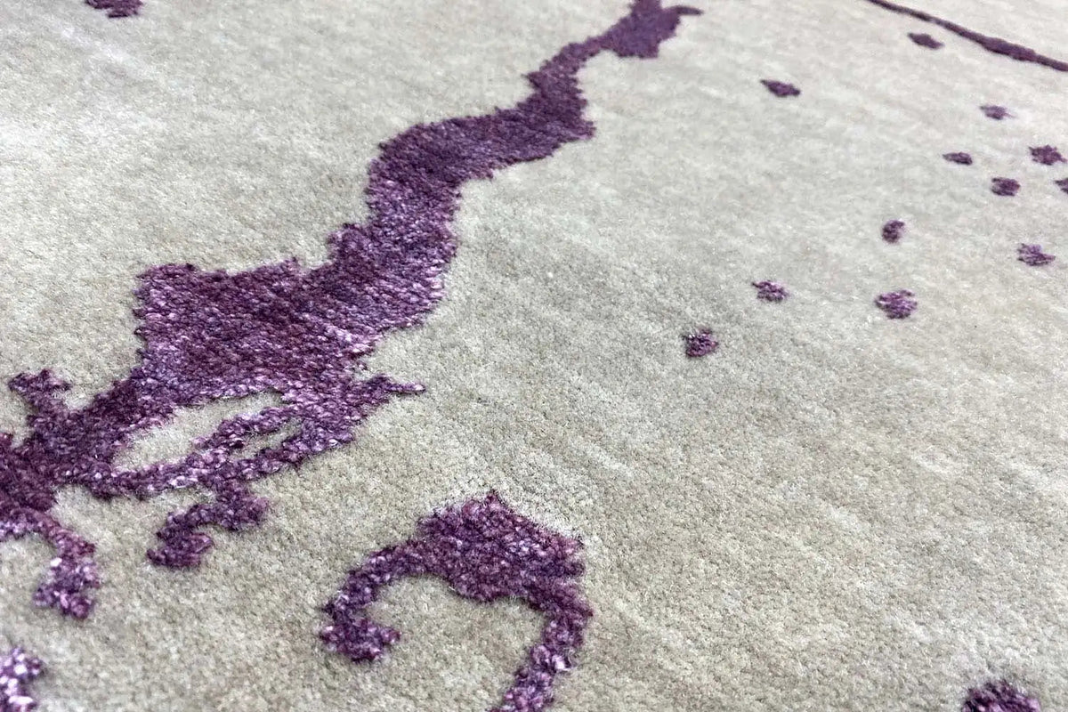 Designer rug: beige pile with a violet ornament, detailed view of the texture
