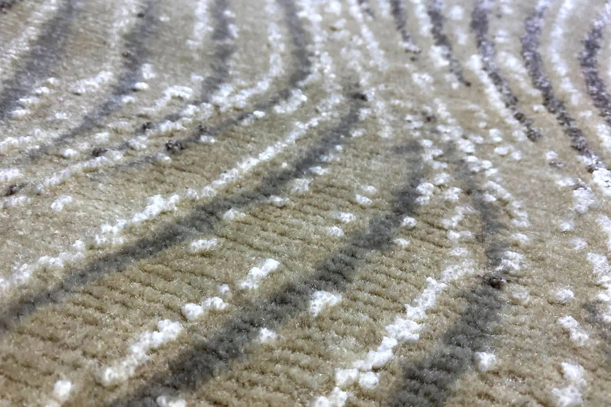 Beige rug with silver-gray, wave-shaped stripes and a lustrous pile texture.
