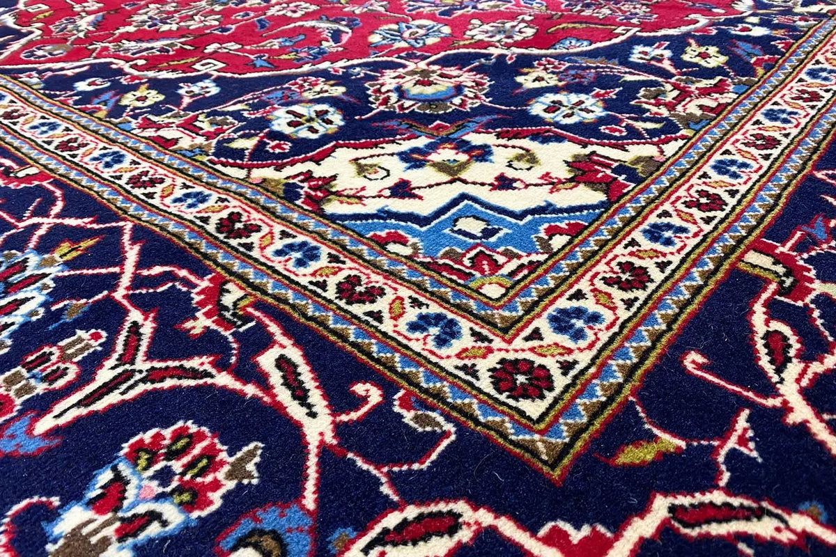 Keshan rug: intricately patterned red and dark blue rug with an ornamental border