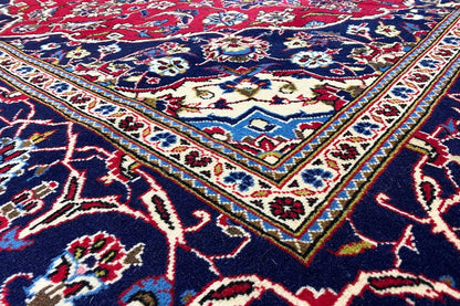 Keshan rug: intricately patterned red and dark blue rug with an ornamental border