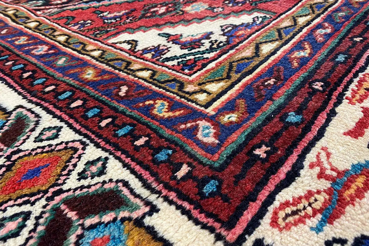 Oriental rug with a multicolored geometric pattern and red border