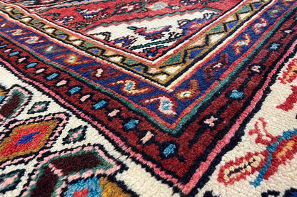 Oriental rug with a multicolored geometric pattern and red border