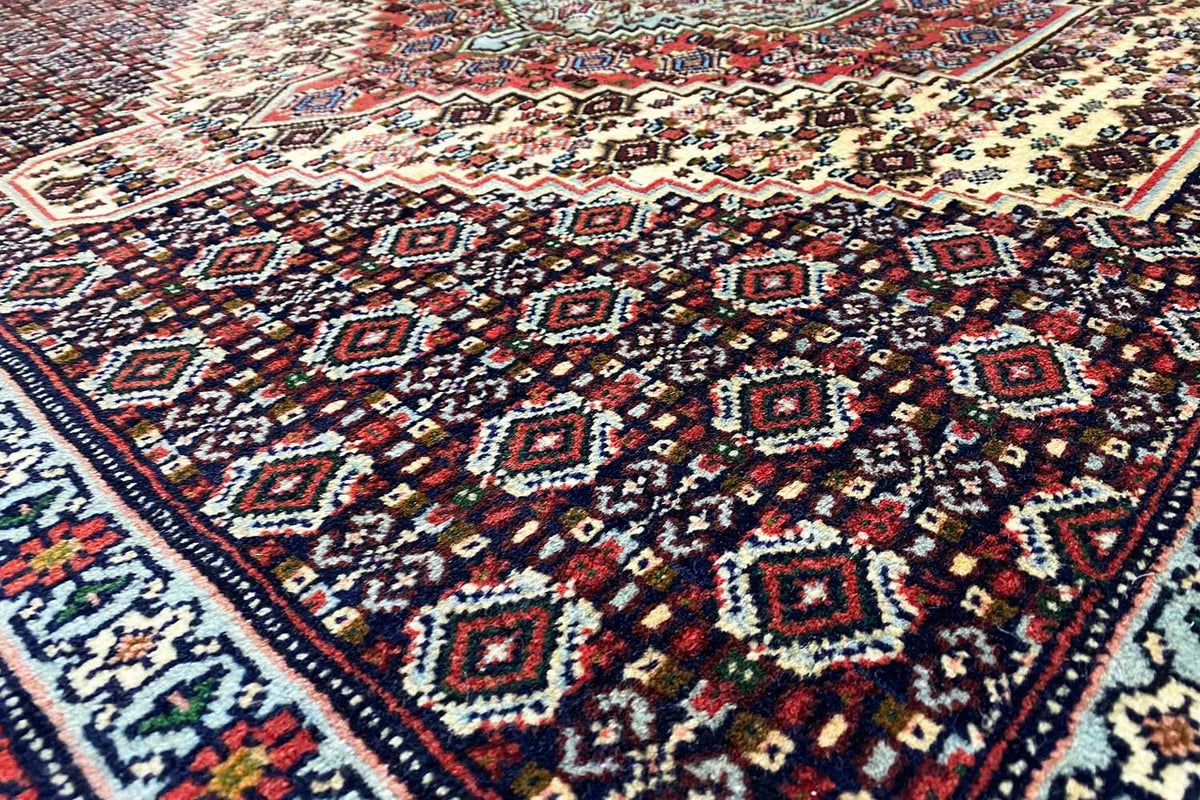 Hamadan rug with a geometric pattern in dark blue, red, and beige tones
