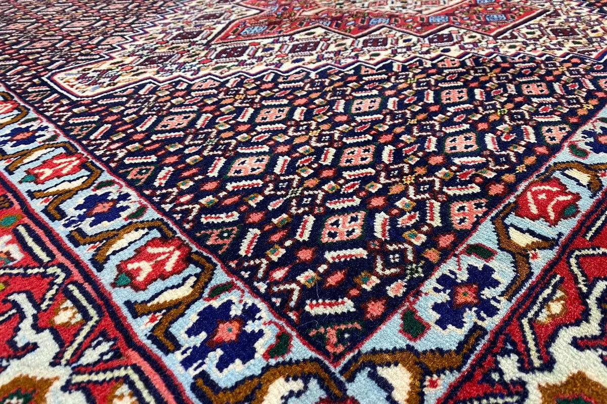 Hamadan rug with a dark pattern of diamonds, medallions, and red accents
