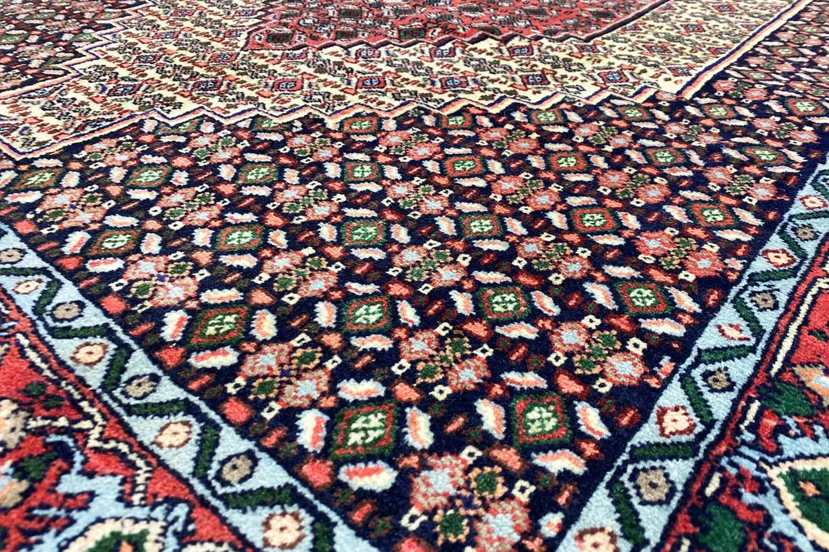 Hamadan rug: intricate pattern in red, blue, and cream, densely woven.