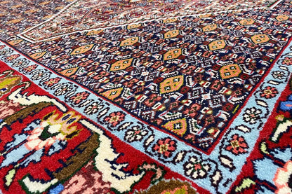 Hamadan rug with a multicolored ornamental pattern and fringes, close-up.