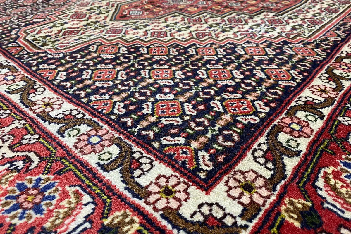 Hamadan rug with a dark blue field, red borders, and a geometric pattern