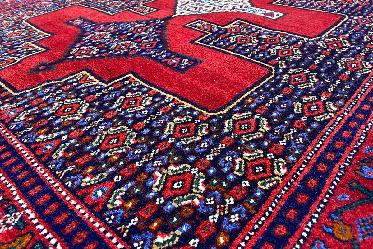 Hamadan rug with a red and blue geometric pattern, central medallions, and border.