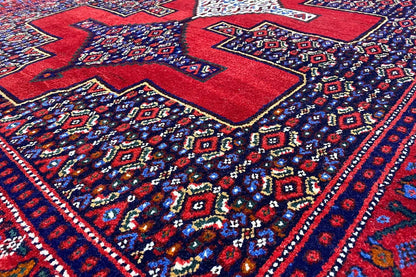 Hamadan rug with a red and blue geometric pattern, central medallions, and border.