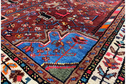 Hamadan rug with a red medallion pattern, multicolored border, and fine pile