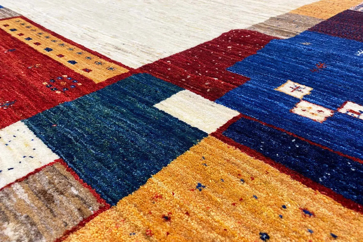 Carpet detail with deep blue pile, red and yellow patchwork, and white accents