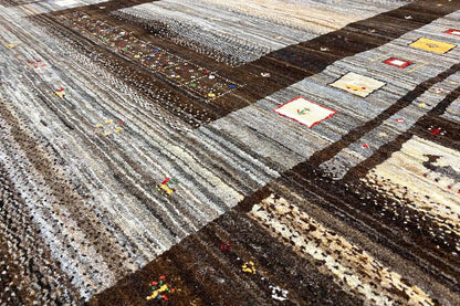 Gabbeh rug with patchwork pattern, dark brown and gray tones, small color details