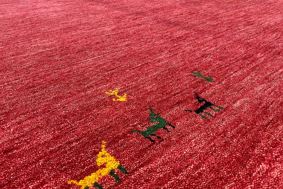 Close-up: red Gabbeh rug with colorful ornaments in the pile