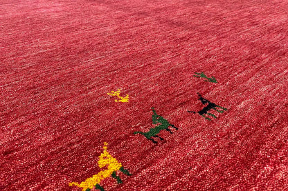 Close-up: red Gabbeh rug with colorful ornaments in the pile