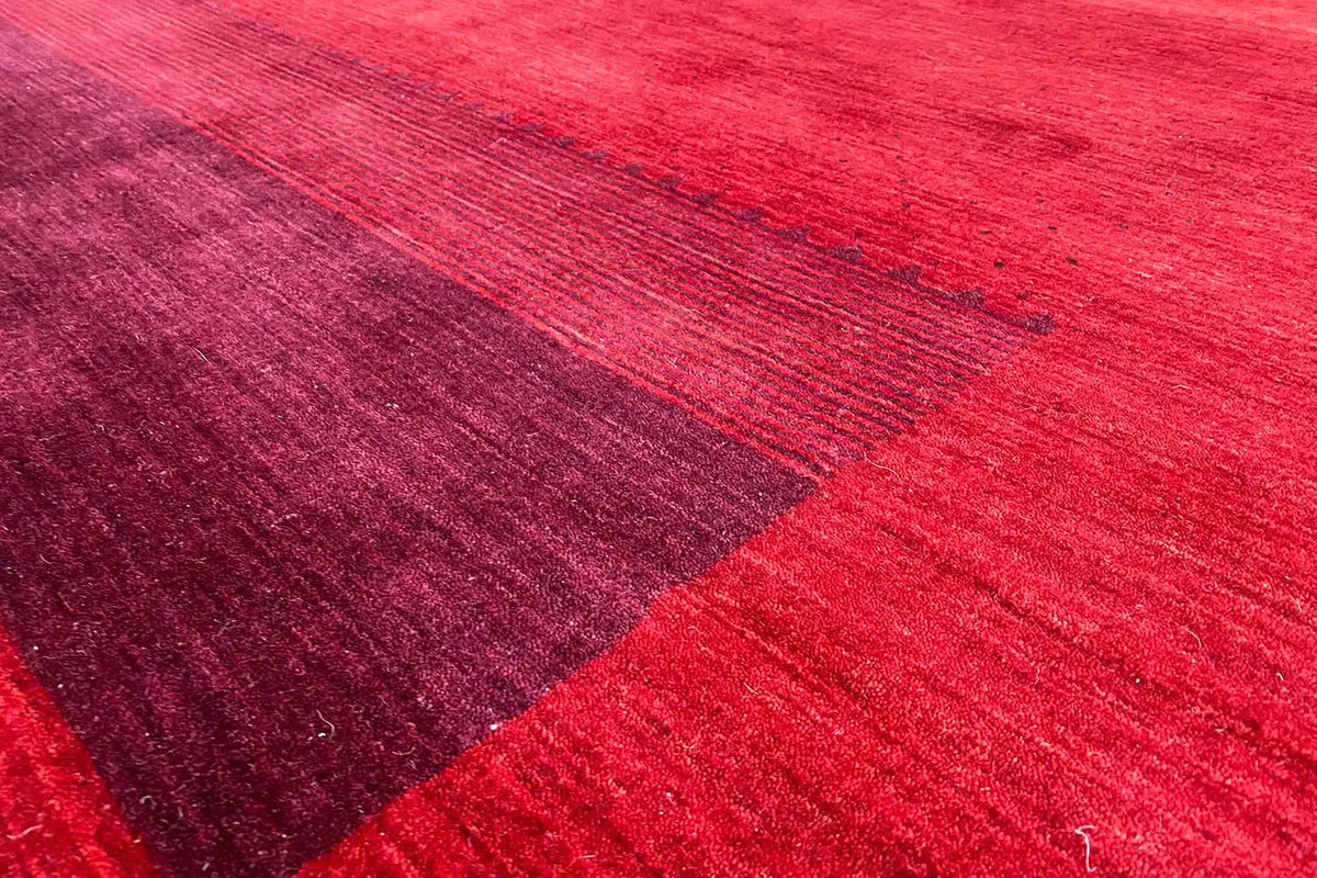 Gabbeh rug detail: red and dark red areas with a fine line pattern