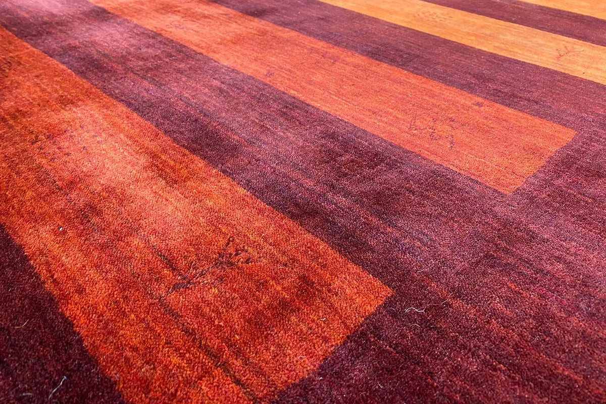 Gabbeh rug with dark red pile and orange stripes