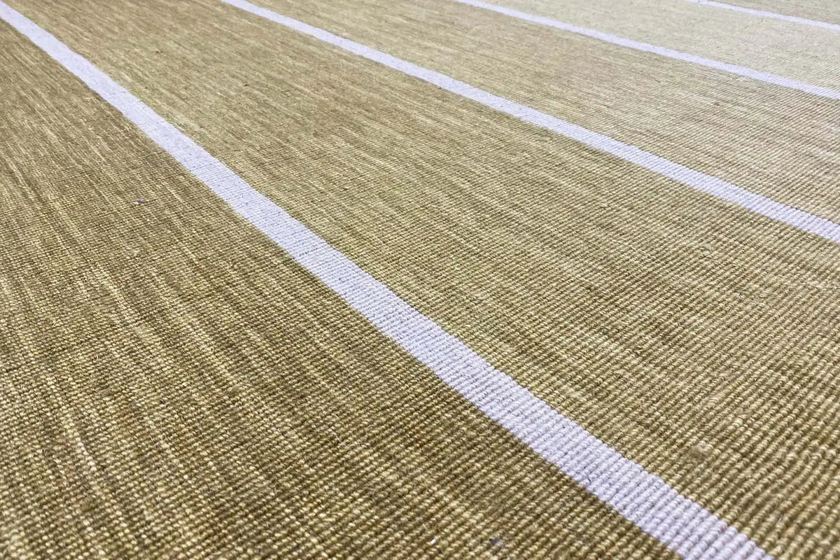 Kilim rug detail: ochre-green woven fabric with wide white stripes