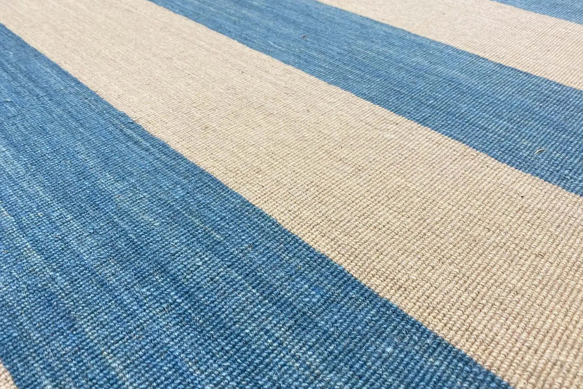 Kilim rug detail: blue and beige striped pattern with a woven texture