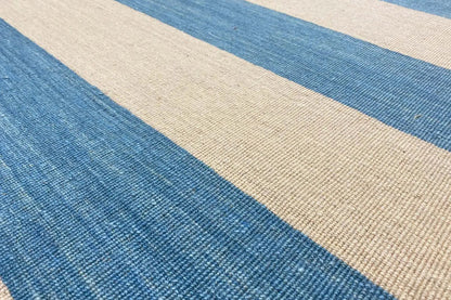 Kilim rug detail: blue and beige striped pattern with a woven texture