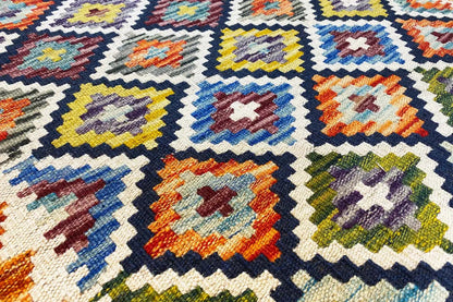 Kelim runner with a geometric pattern in blue, yellow, red, and cream
