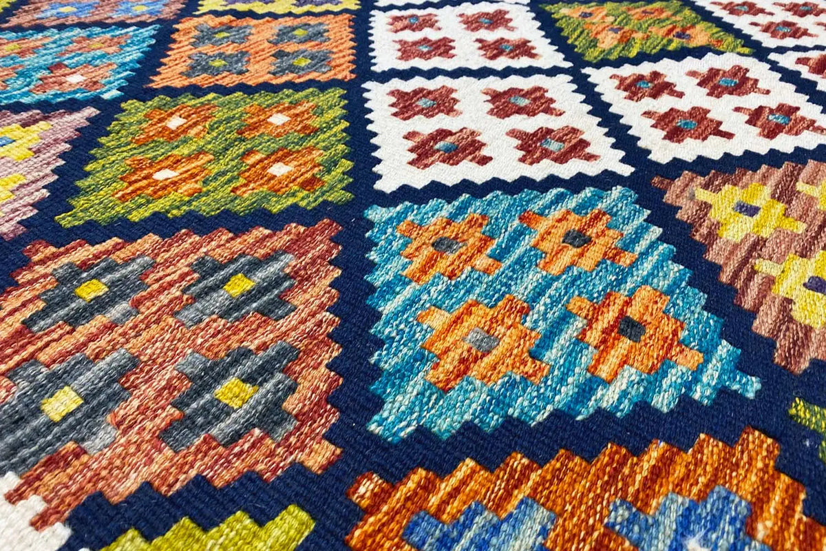 Afghan kilim with a multicolored ornamental pattern and blue central medallion, close-up