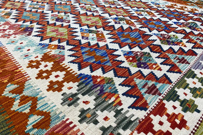 Kilim rug with a geometric pattern in blue, orange, red, and cream