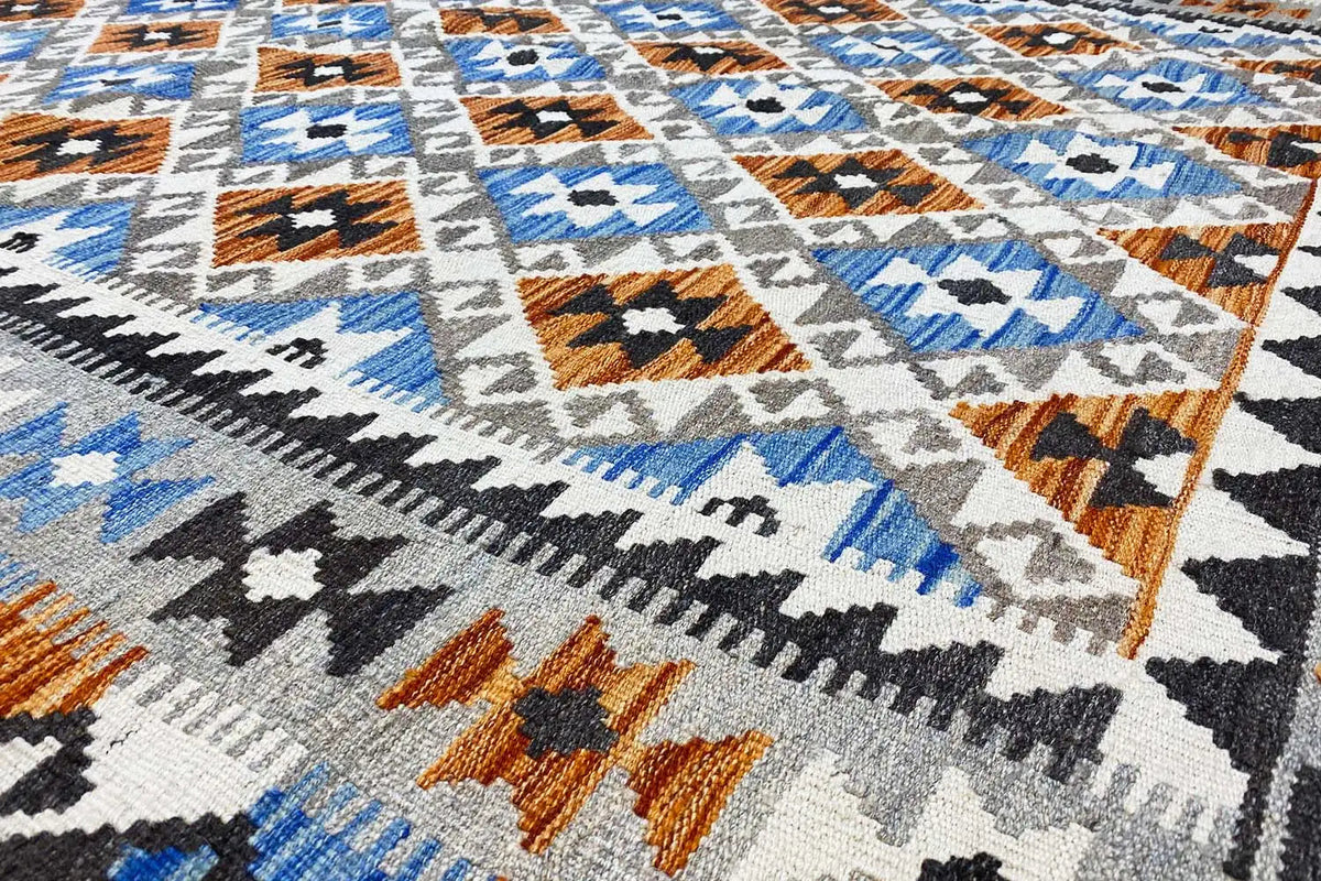 Afghan kilim rug with a geometric pattern in blue, white, brown, and black