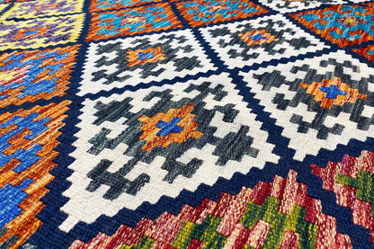 Kilim rug with a geometric pattern, close-up in blue, white, and orange.