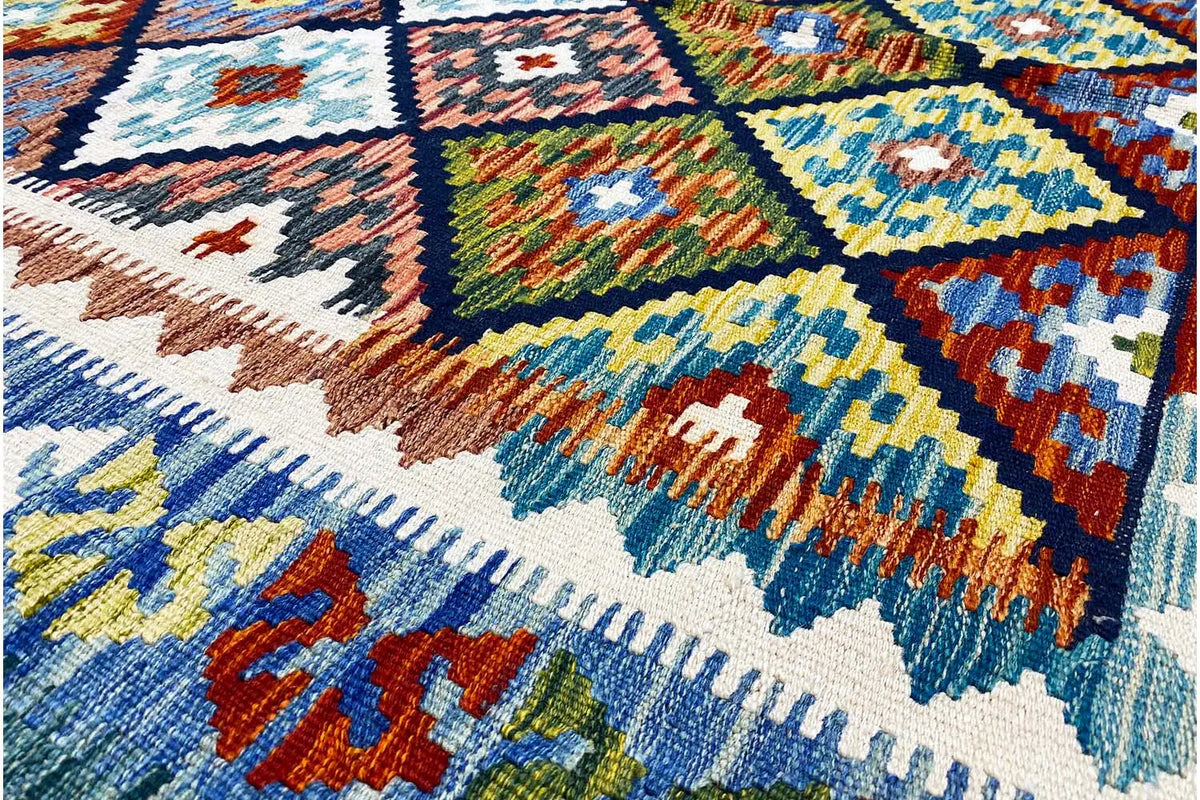 Colorful Afghan kilim with a geometric tile pattern in blue, yellow, red, and green