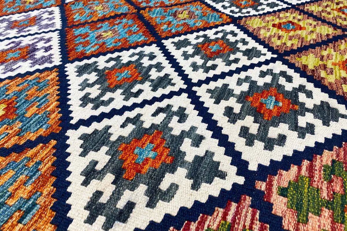 Kilim rug with a geometric pattern in blue, white, and orange