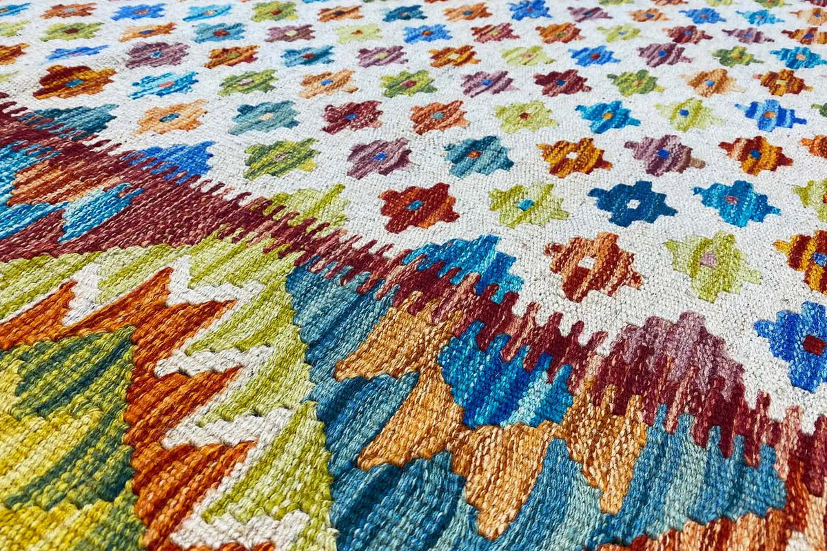 Afghan kilim with a colorful geometric pattern and colorful fringes along the edge
