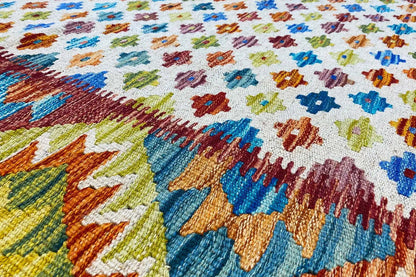 Afghan kilim with a colorful geometric pattern and colorful fringes along the edge