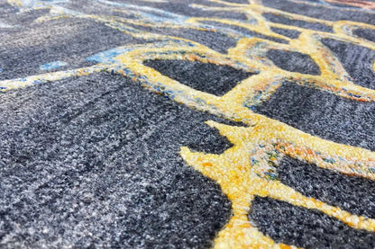 Hand-tufted rug with blue-gray pile and a pattern highlighted in yellow
