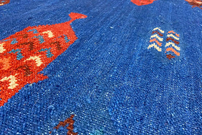 Close-up: blue kilim fabric with a red pattern and fine relief texture