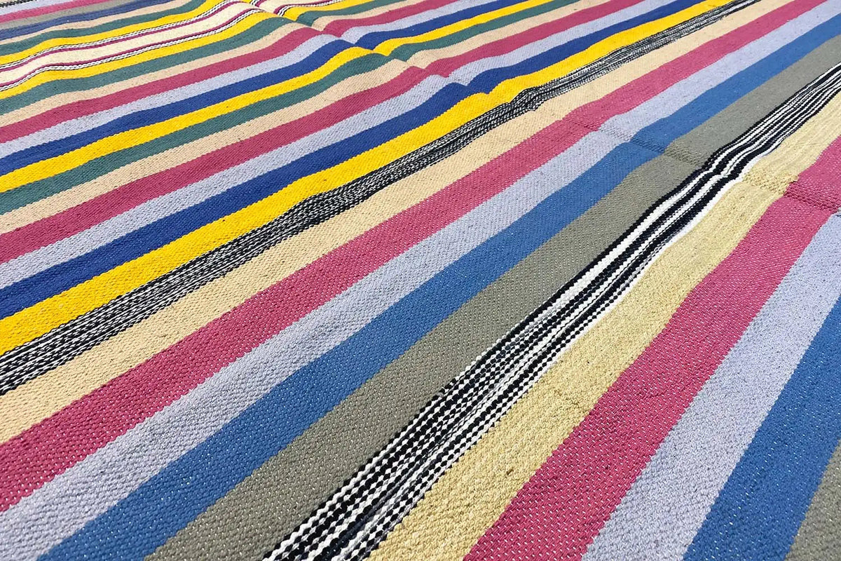 Kilim dhurrie rug with a diagonal stripe pattern in blue, pink, beige, and black