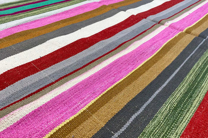Close-up: Kilim dhurrie rug with colorful horizontal stripes and a woven texture