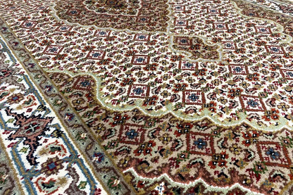 Indo Tabriz rug: intricate pattern with border, cream, brown and green.