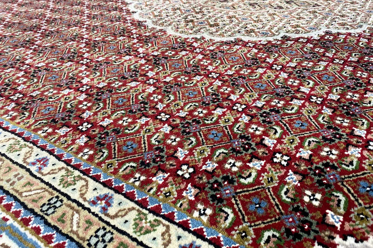 Indo-Tabriz rug with medallion design, red and green ornamentation, and beige border