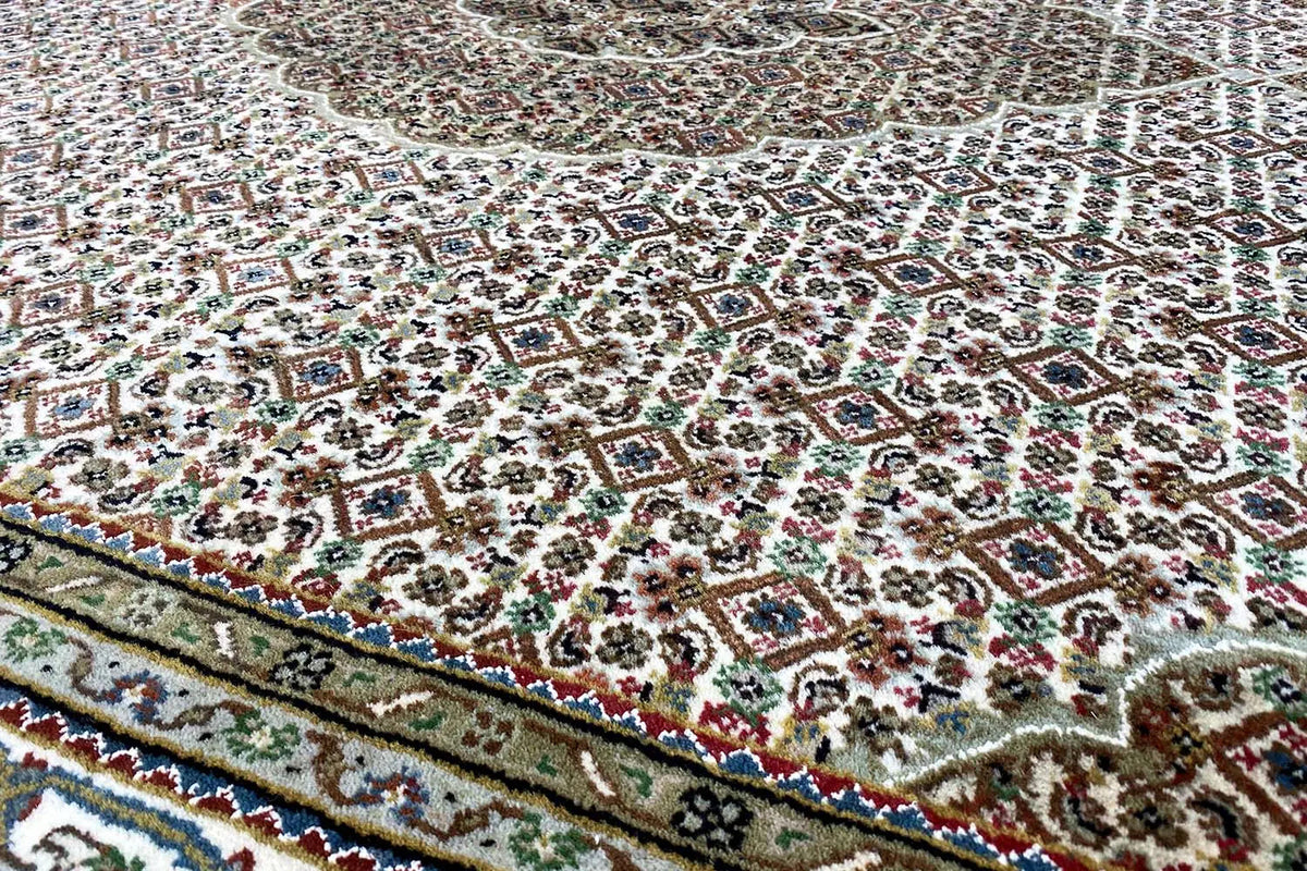 Indo Tabriz rug: patterned pile with a border edge and fringes along the edge