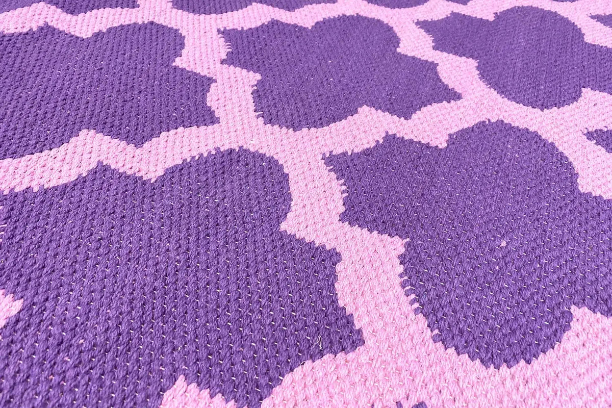 Rug with a purple floral pattern and light accents, detailed woven texture in close-up