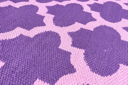Rug with a purple floral pattern and light accents, detailed woven texture in close-up