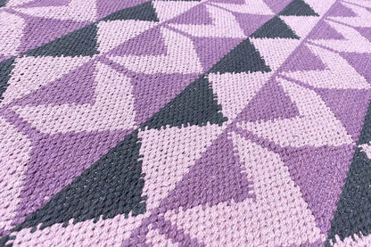 Woven fabric in violet, white and dark gray with geometric patterned sections