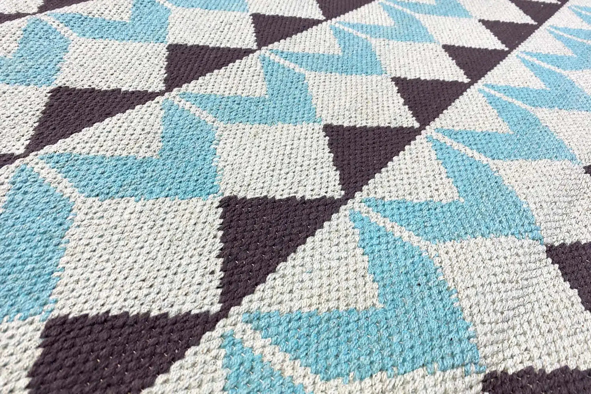 Kilim rug with turquoise and white triangles as well as brown accents; detailed view of the texture