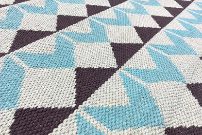 Kilim rug with turquoise and white triangles as well as brown accents; detailed view of the texture