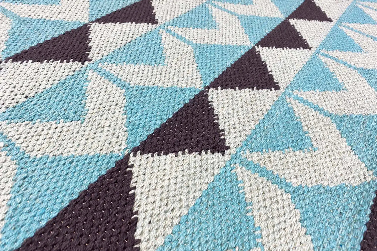 Carpet detail with turquoise areas, white pattern elements, and dark triangles