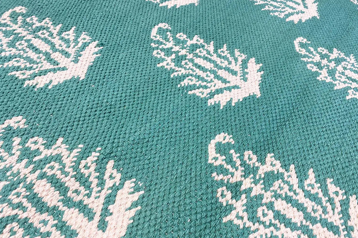 Modern green kilim with a white tree pattern, close-up of the weave structure