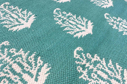 Modern green kilim with a white tree pattern, close-up of the weave structure
