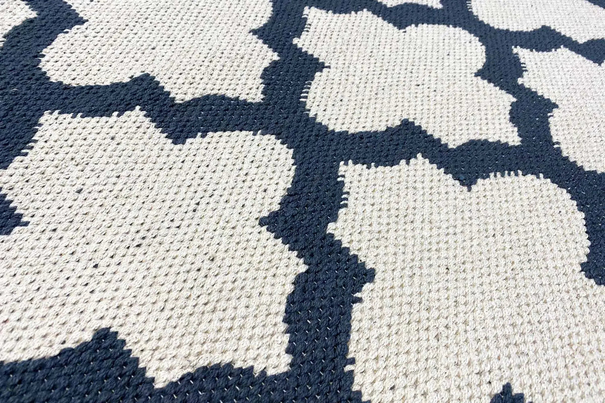 Kelim rug detail view: white geometric pattern on dark blue pile